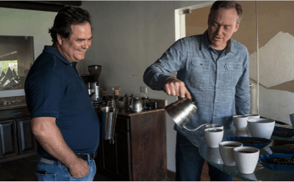 Doug Welsh pouring cups of coffee with a colleague